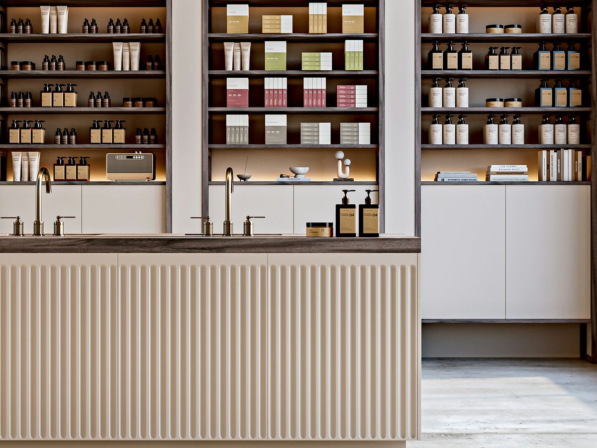 Open timber shelving above a fluted counter front in a minimal retail space.